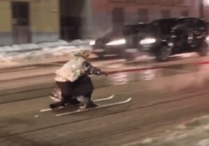 (ВИДЕО) Во Львове мужчина в костюме бабушки катался на лыжах, прицепившись к BMW