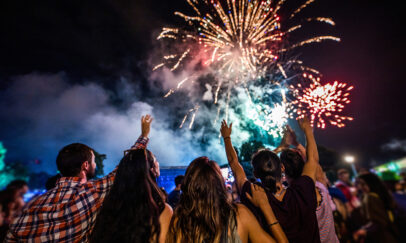Rear view of crowd of people watching fireworks at night.